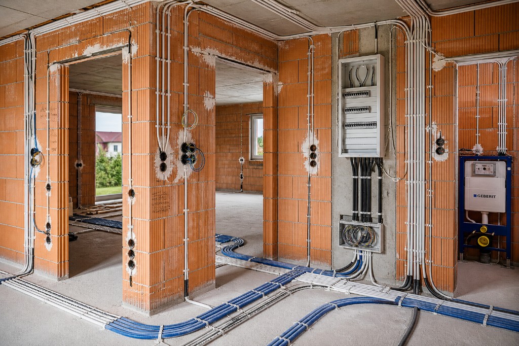 Rohbau mit verlegtem Leitungsnetz und montierter Unterverteilung an Betonstütze vor dem Ausbau